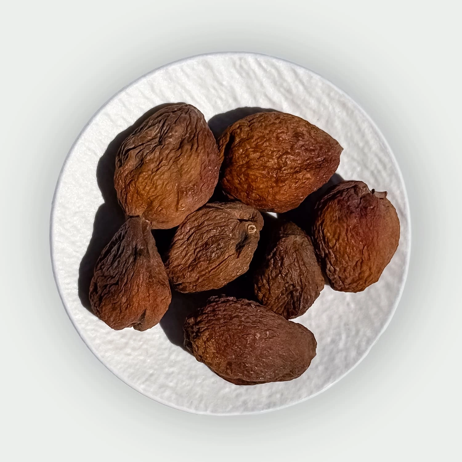 Whole sun-dried apricots with stones on a plate